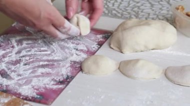 Kadın köfteleri kesme tahtasına koyuyor. Yakın çekim..