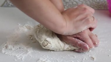 Bir kadın hamur işi için hamur yoğurur. Masanın yüzeyinde. Patatesli hamur tatlısı ve kıyma. Yakın çekim.