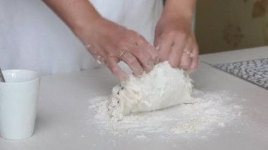 Bir kadın hamur işi için hamur yoğurur. Masanın yüzeyinde. Patatesli hamur tatlısı ve kıyma. Yakın çekim..