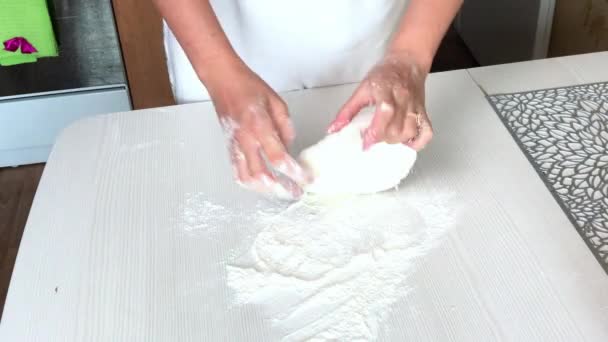 En kvinna knådar deg för dumplings med händerna. Koka dumplings med potatis och malet kött — Stockvideo