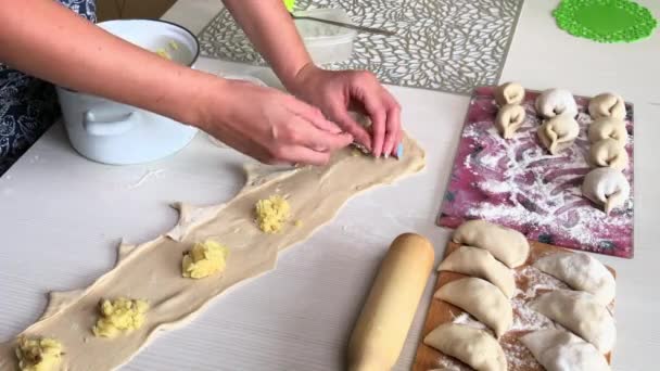 Una donna avvolge purè di patate in pasta arrotolata. Prepara gnocchi ripieni. — Video Stock
