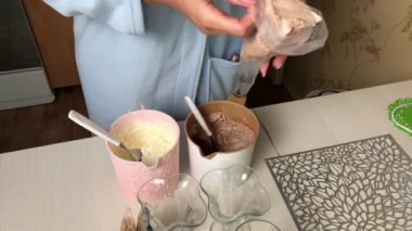 Kadın pasta poşetlerine krema koyar. Krema ve bisküvi kırıntılarıyla tatlı hazırlar..