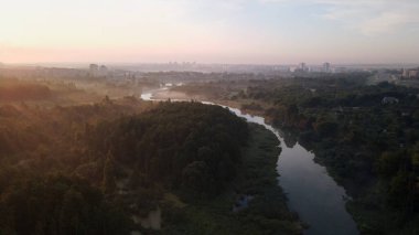 Şehir parkı, nehir akıyor. Şafakta, gün doğumunda vuruldu. Hava fotoğrafçılığı.