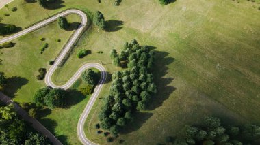 Parkta bir bisiklet yolu. Ağaçların ve çalıların arasındaki rüzgarlar. Hava fotoğrafçılığı.