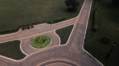 Parkta bir bisiklet yolu. Ağaçların ve çalıların arasından esiyor. Şafakta, gün doğumunda çekildi. Hava fotoğrafçılığı.