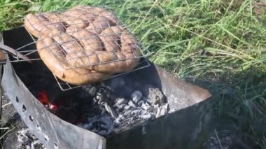 Sosisli ızgara rafı. Közlerle ızgarada yatıyor. Çayırda, yeşil çimlerin arasında. Doğada piknik. Yakın çekim..