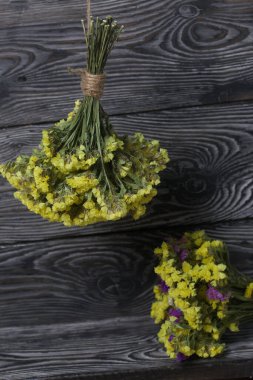 İki buket statik. Biri sarı, diğeri çok renklidir. Çam ağacının arka planında.