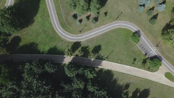 飞越城市公园 在下面可以看到一条弯曲的自行车道 一阵大风吹倒了树木 空中摄影 — 图库视频影像