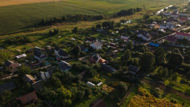Tarım tarlalarıyla çevrili küçük bir köy. Gün batımında çekilmiş. Hava fotoğrafçılığı.
