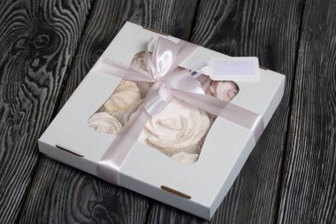 El yapımı ambalajlarda ev yapımı şekerlemeler. Gül şeklinde bir Zephyr. Kurdelelerle süslenmiş. Çam ağacının üzerinde yatıyor.