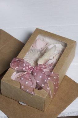 El yapımı ambalajlarda ev yapımı şekerlemeler. Gül şeklinde bir Zephyr. Kurdele ve lagurularla süslenmiş. Yakın çekim..