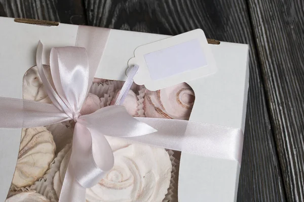 El yapımı ambalajlarda ev yapımı şekerlemeler. Gül şeklinde bir Zephyr. Kurdelelerle süslenmiş. Çam ağacının üzerinde yatıyor.