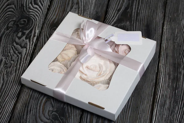 El yapımı ambalajlarda ev yapımı şekerlemeler. Gül şeklinde bir Zephyr. Kurdelelerle süslenmiş. Çam ağacının üzerinde yatıyor.