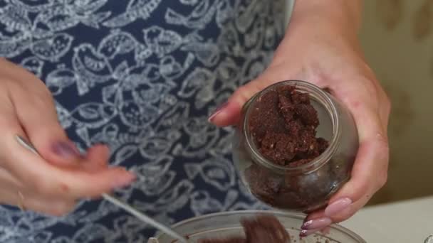 Uma mulher coloca manteiga de noz de uma tigela de liquidificador em um frasco. Urbech de noz. Os ingredientes estão na mesa lado a lado. Imagem de close-up. — Vídeo de Stock