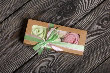 Zephyr el sanatları ambalajında. Gül şeklinde marşmelov. Pembe ve açık yeşil renklerde. Kurdeleyle bağlanmış. Yakın çekim..