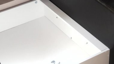 Adam evde mobilya koleksiyonu yapıyor. Sandalye yatağı takıyor. Fındıkları sıkılaştırır. Yakın çekim..