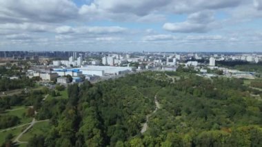 Şehir manzarası. Yakınlarda bir park alanı var. Beyaz bulutlu mavi gökyüzü. Hava fotoğrafçılığı.