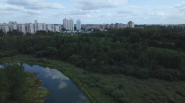 Şehir manzarası. Yakınlarda bir park alanı var. Beyaz bulutlu mavi gökyüzü. Hava fotoğrafçılığı.