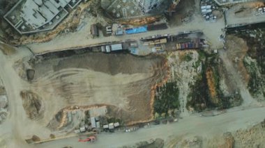 Modern bir şehir bloğunun inşaat alanı. Yüksek binalar yapım aşamasında. İnşaat kulesi vinçleri. Gün batımında hava fotoğrafçılığı.