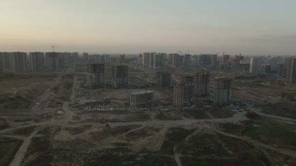 近代的な都市ブロックの建設現場 高層ビルの建設中 建設タワークレーン 日没時の空中写真 — ストック動画