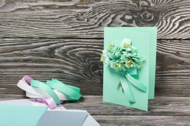 El yapımı kartpostal. Yakınlarda kartpostal yapmak için malzemeler var. Siyah çam tahtalarında.