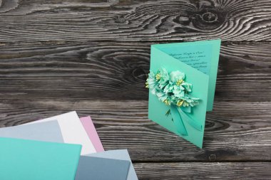 El yapımı kartpostal. Yakınlarda kartpostal yapmak için malzemeler var. Siyah çam tahtalarında.