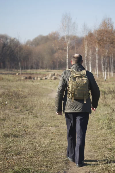 Mann mit Rucksack auf den Schultern zu Fuß auf Weg in Park — Stockfoto