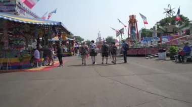 Falcon Heights, Minnesota 'da. Minnesota eyalet fuarı. İnsanlar yolun ortasındaki caddelerden birinde yürüyor. Satıcıları ve yol boyunca at binenleri kontrol ediyorlar.. 