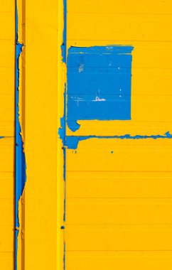 Soyulmuş sarı boyanın altından süzülen mavi boya lekeleriyle ön cephenin bir parçasında soyut çizimler oluştu..