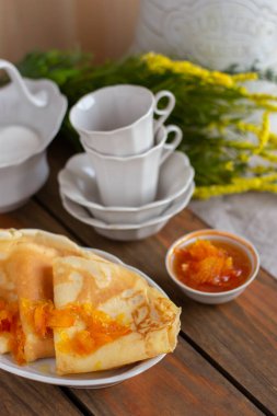 İnce krep ve portakal reçeli veya marmelatlı ahşap arka plan. Lezzetli bir kahvaltı. Maslenitsa.