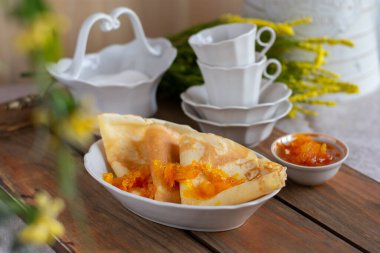 İnce krep ve portakal reçeli veya marmelatlı ahşap arka plan. Lezzetli bir kahvaltı. Maslenitsa.