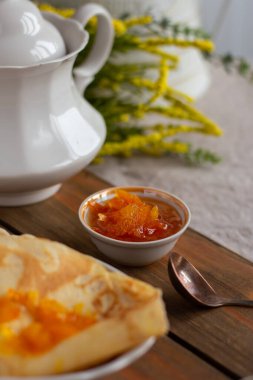 İnce krep ve portakal reçeli veya marmelatlı ahşap arka plan. Lezzetli bir kahvaltı. Maslenitsa.