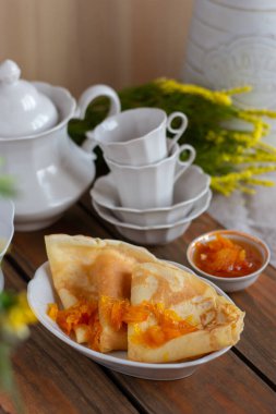 İnce krep ve portakal reçeli veya marmelatlı ahşap arka plan. Lezzetli bir kahvaltı. Maslenitsa.