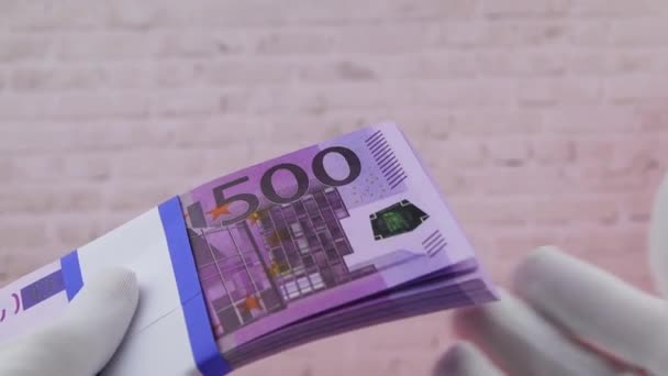 Ręka w białej rękawicy trzyma stos banknotów papierowych 500 euro, zbliżenie, FullHD — Wideo stockowe