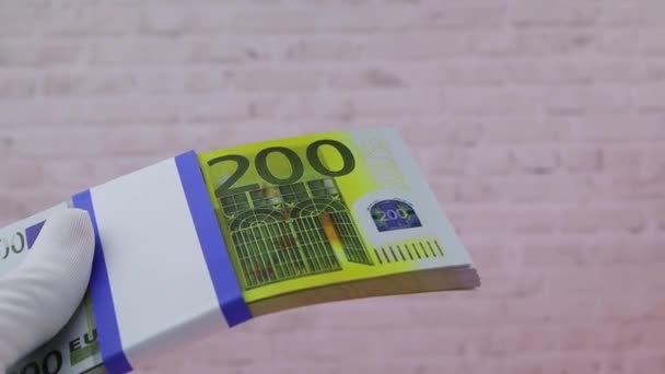 Рука в білій рукавичці тримає купу банкнот в 200 євро (англ. Close-up, FullHD) — стокове відео