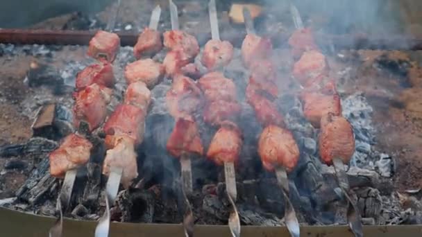 Las brochetas de cerdo marinadas se cocinan lentamente en brochetas de metal en la parrilla — Vídeos de Stock