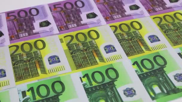 Une main dans une chemise balaie les billets de 100, 200 et 500 euros disposés en rang. — Video