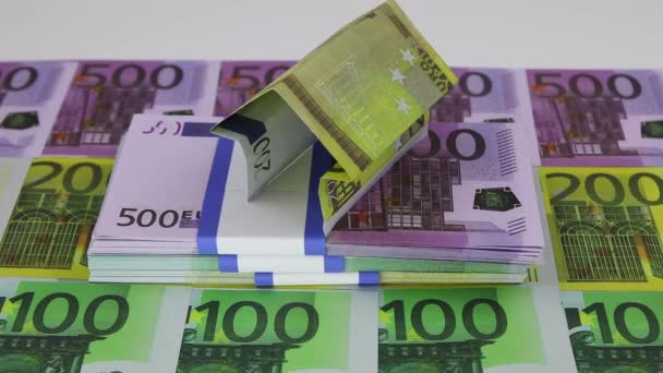 A house made of a 200 euro banknote standing on wads of money flies away sharply — Stock Video