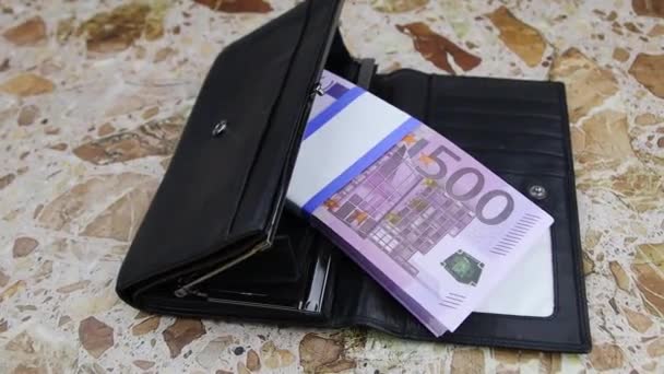 500 유로짜리 지폐 한 묶음이, 풀 HD (FullHD) 라는 석판 위에 검은 지갑에 놓여 있다 — 비디오
