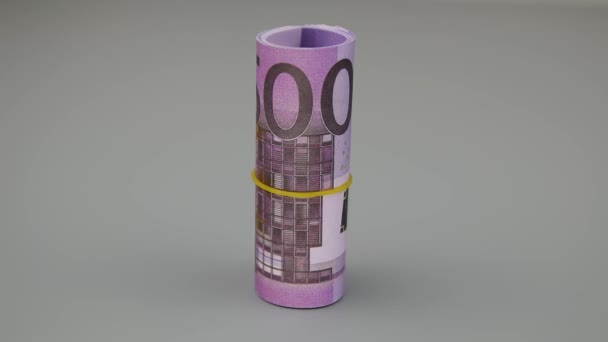 Una mano in un guanto bianco solleva 500 banconote in euro rotolate da una pila di monete — Video Stock