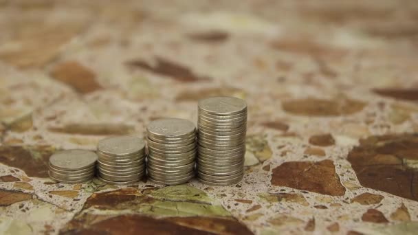 A hand in a white glove puts rolled 10 euro banknotes next to stacks of coins — Stock Video