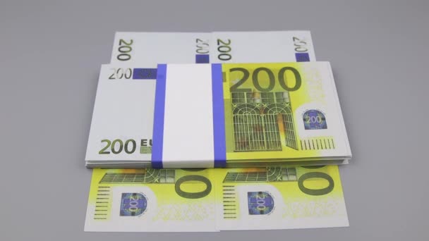 La main dans un gant noir ramasse un paquet de billets de 200 euros couchés sur la table — Video