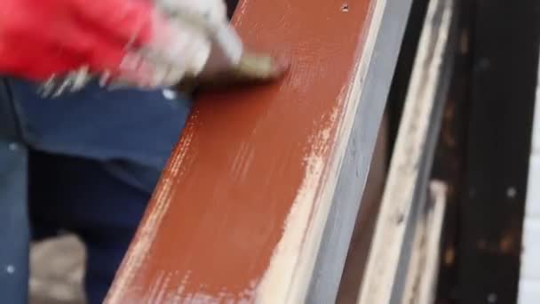 Femme ouvrière en gants peint la surface supérieure de la main courante en bois brun — Video