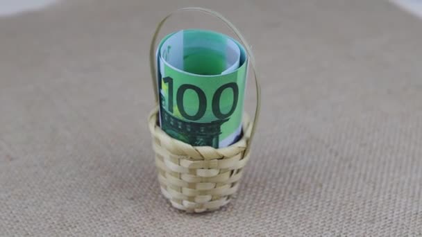 Rullade 100 eurosedlar placerade i en liten korg roterar på ett rundabordsbord — Stockvideo