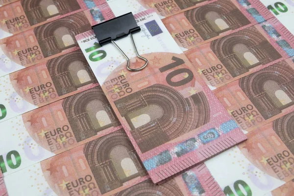 Un paquet de billets scellés avec une agrafe de papeterie se trouve sur 10 billets en euros — Photo