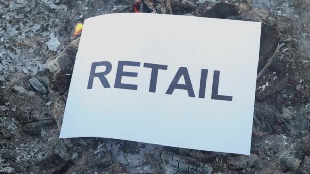 Word Retail su un foglio bianco di carta brucia in un fuoco contro. Rallentatore — Video Stock