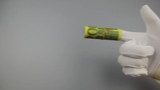 Ruka v bílé rukavici s ukazováčkem 200 Euro střílí do strany — Stock video