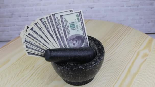 Vaso de pedra com notas de 100 dólares gira sobre mesa de madeira — Vídeo de Stock