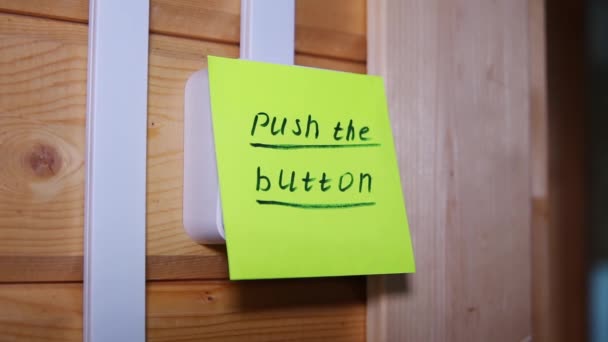 Dedo pressiona o adesivo com a inscrição Pressione o botão no interruptor — Vídeo de Stock