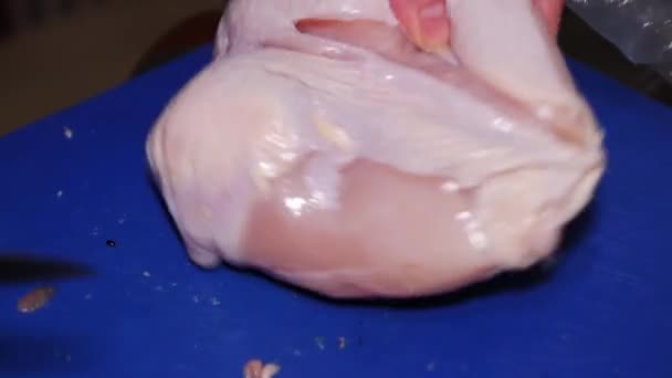 Woman cuts chicken breast with knife on blue board, FullHD — ストック動画